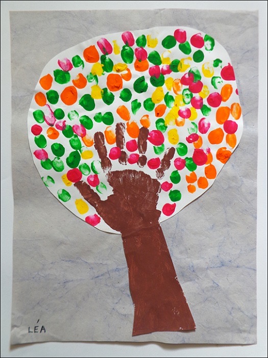 Arbre peint avec des empreintes de main et de doigts colorées